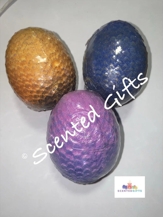 Magical Dragon Essential Oil Egg Bath Bomb. Dragon egg shaped bomb coloured in yellow, blue and purple with embeds hidden inside the bomb.. Scented in the shaman, aphrodites dawn and fruit of sulis.
