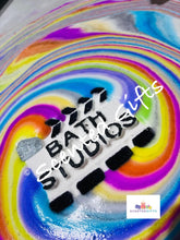 Load image into Gallery viewer, Bath Studios bath bomb A white and black bath studios action shaped bath bomb scented in fruity and fun raspberry crush fragrance with hidden rainbow colours. Weighing in at 200g approx.