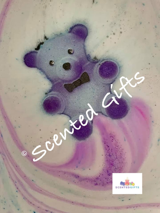 Jumbo Teddy Bath Bomb A blue coloured shaped teddy shaped bath bomb with purple mica detail and coloured embeds inside the bath bomb, scented in baby powder.