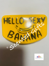 Load image into Gallery viewer, Hello Sexy Banana bath bomb    A yellow bath bomb with black detailed writing hello sexy banana with hidden colours and scented in banana milkshake. 
